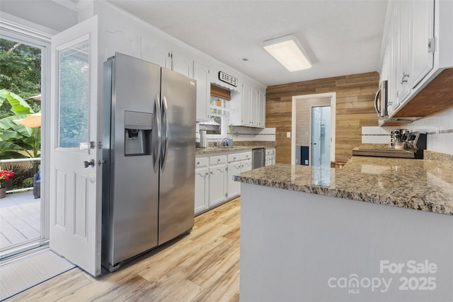 1507 Breckenwood Dr, Rock Hill, SC 29732 - kitchen featuring stainless steel appliances, white cabinets, plenty of natural light, a peninsula, and wooden walls