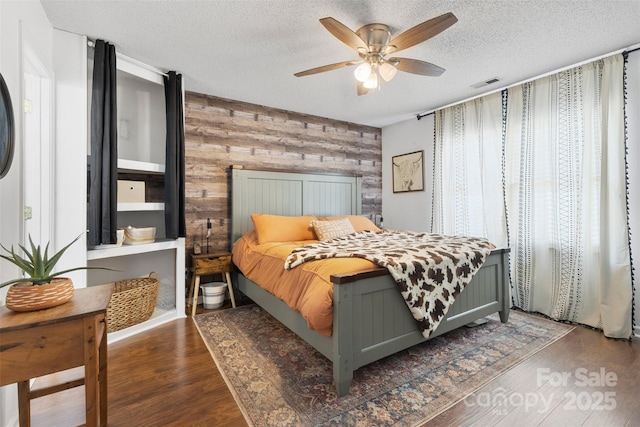 1507 Breckenwood Dr, Rock Hill, SC 29732 - bedroom featuring wooden walls, an accent wall, wood finished floors, a textured ceiling, and ceiling fan