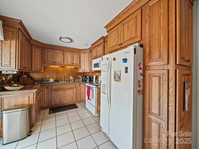 3471 Greentree Acres Rd, Valdese, NC 28690 - kitchen featuring white appliances, light tile patterned floors, brown cabinetry, and tasteful backsplash