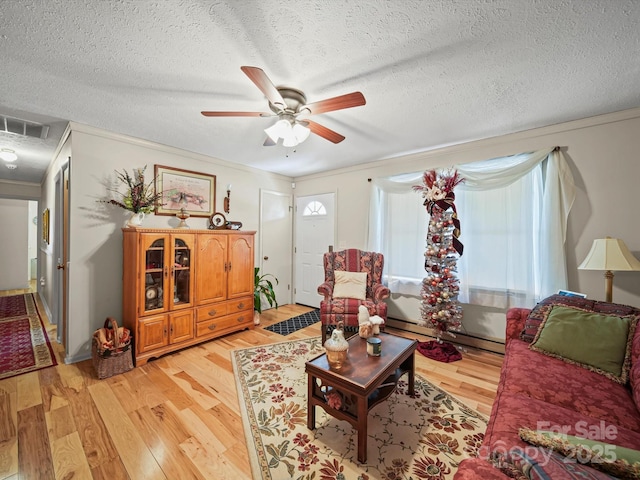 3471 Greentree Acres Rd, Valdese, NC 28690 - living room featuring baseboard heating, light wood-type flooring, a ceiling fan, and a textured ceiling