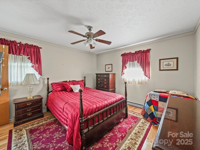 3471 Greentree Acres Rd, Valdese, NC 28690 - bedroom with wood finished floors, a baseboard heating unit, multiple windows, ornamental molding, and a textured ceiling