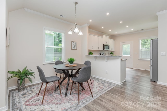 1514 Starmount Cove Ln, Charlotte, NC 28210 - dining room featuring ornamental molding, plenty of natural light, light wood-type flooring, and recessed lighting