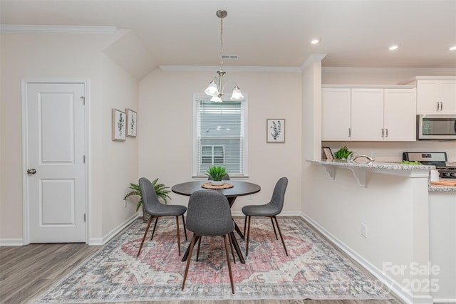 1514 Starmount Cove Ln, Charlotte, NC 28210 - dining space featuring wood finished floors, ornamental molding, a chandelier, and recessed lighting