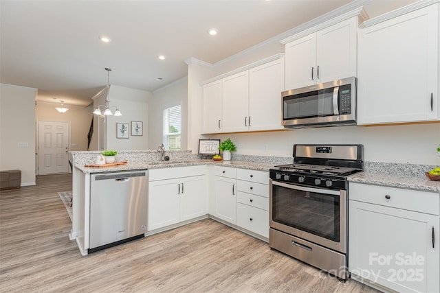 1514 Starmount Cove Ln, Charlotte, NC 28210 - kitchen with stainless steel appliances, a peninsula, white cabinets, ornamental molding, and light wood-style floors