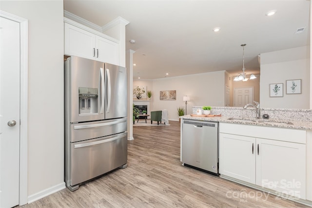 1514 Starmount Cove Ln, Charlotte, NC 28210 - kitchen featuring stainless steel appliances, a fireplace, white cabinetry, light wood finished floors, and recessed lighting
