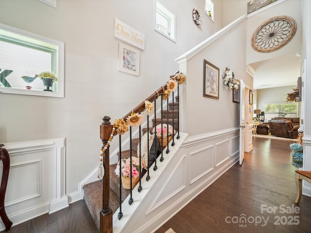 9428 Carneros Creek Rd, Charlotte, NC 28214 - stairway featuring wood finished floors, a towering ceiling, and wainscoting