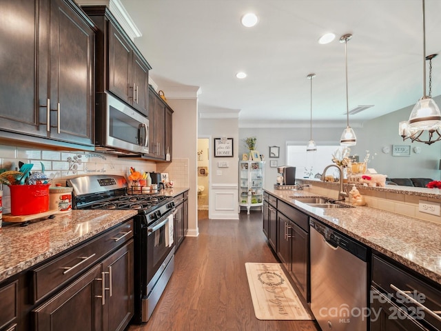 9428 Carneros Creek Rd, Charlotte, NC 28214 - kitchen featuring stainless steel appliances, crown molding, light stone counters, dark brown cabinets, and dark wood finished floors