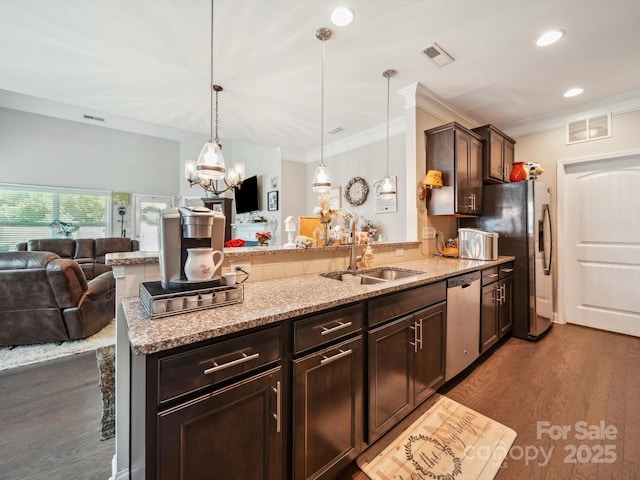 9428 Carneros Creek Rd, Charlotte, NC 28214 - kitchen with appliances with stainless steel finishes, a peninsula, open floor plan, light stone countertops, and ornamental molding