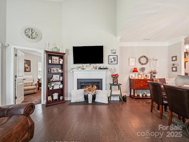 9428 Carneros Creek Rd, Charlotte, NC 28214 - living area with a lit fireplace, dark wood-style flooring, and crown molding