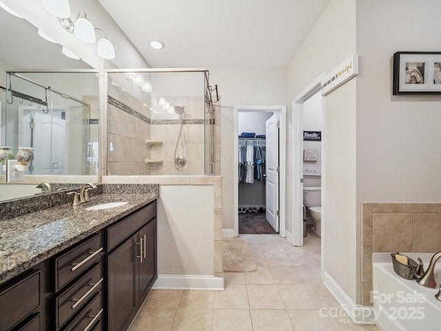 9428 Carneros Creek Rd, Charlotte, NC 28214 - full bathroom with a stall shower, vanity, a bath, tile patterned floors, and a walk in closet