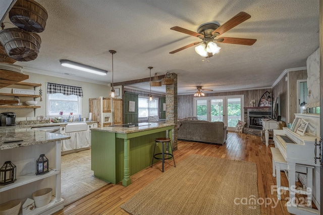 665 Will Robbins Ln, Newland, NC 28657 - kitchen featuring open shelves, ceiling fan, a textured ceiling, a breakfast bar, and light wood-type flooring
