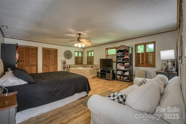 665 Will Robbins Ln, Newland, NC 28657 - bedroom featuring light wood-style flooring, a ceiling fan, and two closets