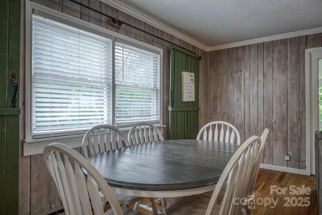 665 Will Robbins Ln, Newland, NC 28657 - dining space with plenty of natural light, crown molding, wood walls, wood finished floors, and a textured ceiling