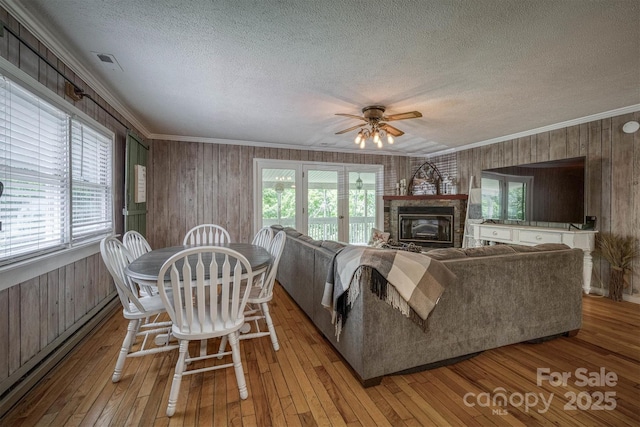 665 Will Robbins Ln, Newland, NC 28657 - living room featuring wooden walls, ornamental molding, a textured ceiling, healthy amount of natural light, and light wood-type flooring
