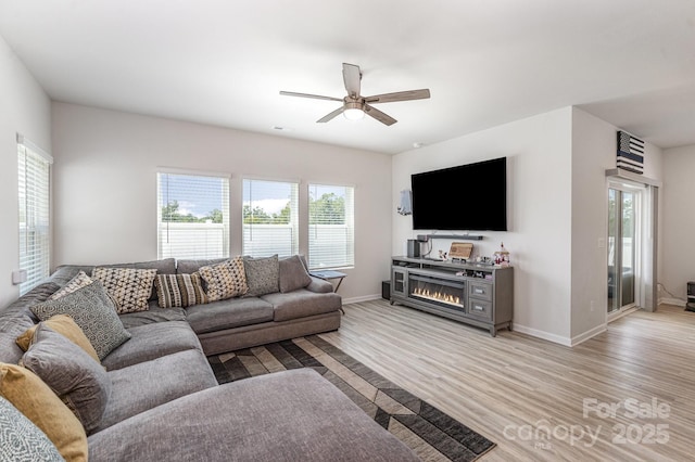 1010 Harry Ct, Albemarle, NC 28001 - living room with light wood-style floors, ceiling fan, and a lit fireplace