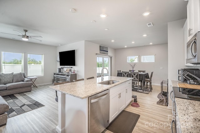 1010 Harry Ct, Albemarle, NC 28001 - kitchen with stainless steel appliances, open floor plan, white cabinets, light wood-type flooring, and a kitchen island with sink