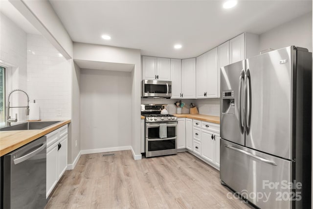 204 Terrys Gap Loop Rd, Fletcher, NC 28732 - kitchen with appliances with stainless steel finishes, wood counters, decorative backsplash, white cabinets, and recessed lighting
