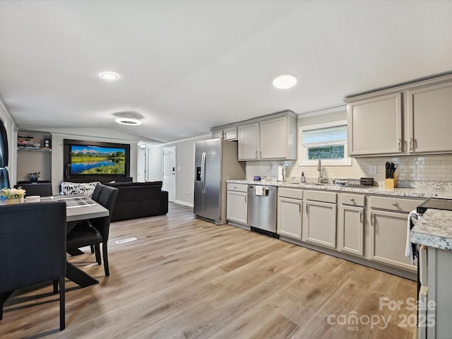 1140 Randall Ct, Concord, NC 28025 - kitchen featuring stainless steel appliances, vaulted ceiling, light wood finished floors, open floor plan, and decorative backsplash