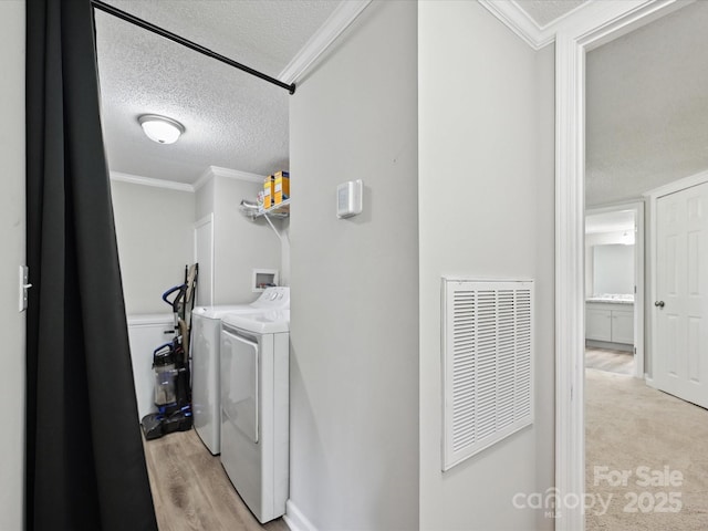 1140 Randall Ct, Concord, NC 28025 - washroom with washer and clothes dryer, a textured ceiling, ornamental molding, and light wood-type flooring