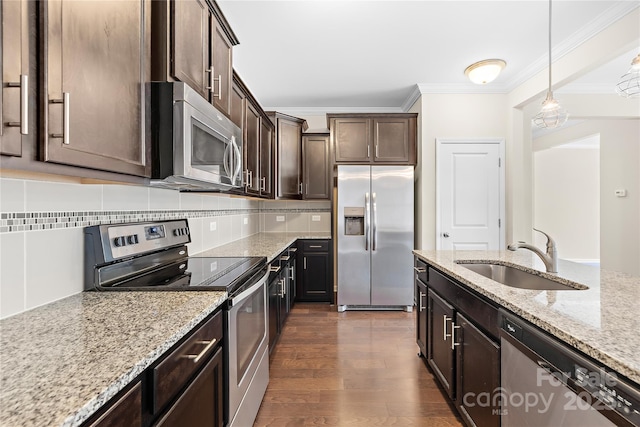 921 Summerlake Dr, Fort Mill, SC 29715 - kitchen featuring appliances with stainless steel finishes, ornamental molding, dark brown cabinets, light stone counters, and pendant lighting