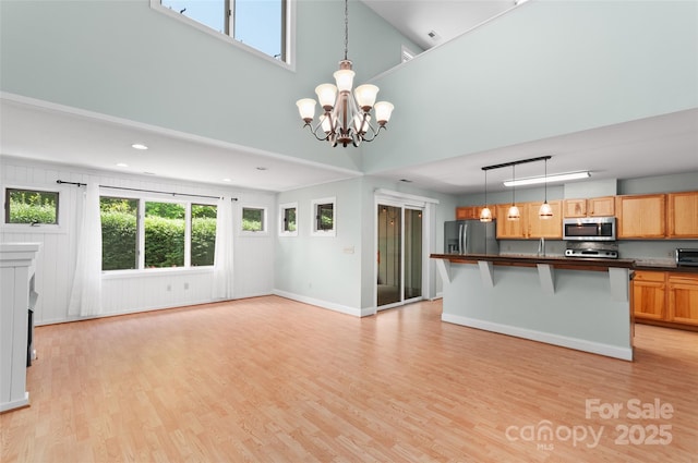 38 Live View Ln, Clyde, NC 28721 - kitchen featuring appliances with stainless steel finishes, a towering ceiling, a chandelier, dark countertops, and open floor plan