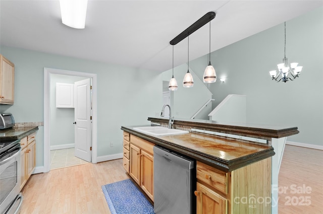 38 Live View Ln, Clyde, NC 28721 - kitchen featuring stainless steel appliances, dark countertops, light wood-type flooring, a kitchen island with sink, and decorative light fixtures