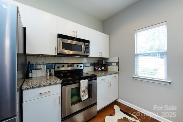 432 W Worthington Ave, Charlotte, NC 28203 - kitchen with appliances with stainless steel finishes, decorative backsplash, dark wood-style floors, and white cabinetry