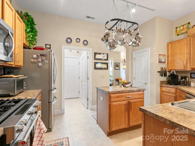 91 Talon Trail Ln, Etowah, NC 28729 - kitchen featuring appliances with stainless steel finishes, a chandelier, light tile patterned floors, track lighting, and a center island