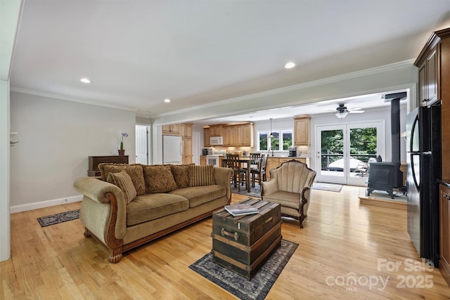 6411 Glenn Teague Rd, Charlotte, NC 28216 - living room featuring a wood stove, light wood finished floors, ornamental molding, recessed lighting, and ceiling fan