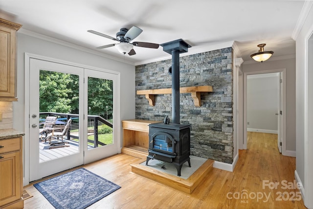 6411 Glenn Teague Rd, Charlotte, NC 28216 - living room featuring a wood stove, crown molding, ceiling fan, and light wood finished floors