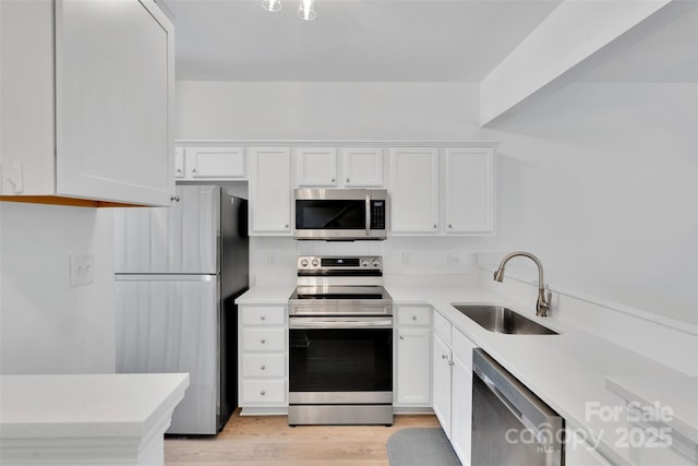 222 Ross Moore Ave, Charlotte, NC 28205 - kitchen with stainless steel appliances, white cabinets, light countertops, and light wood-style floors