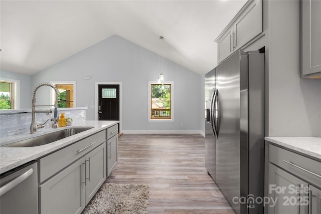 2513 Rolfe St, Hendersonville, NC 28791 - kitchen featuring stainless steel appliances, gray cabinets, light wood-type flooring, vaulted ceiling, and backsplash