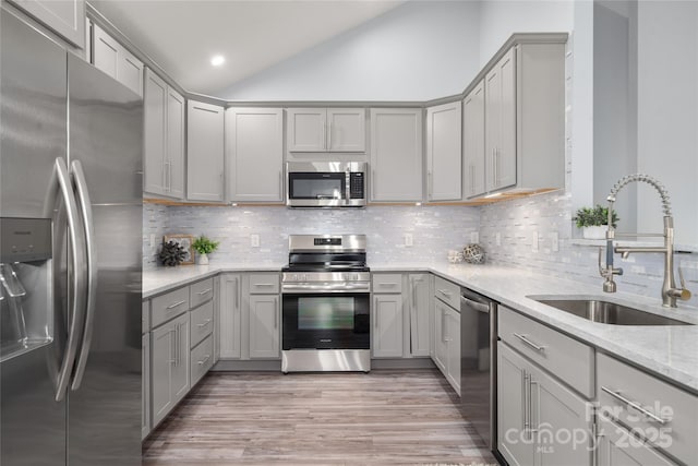 2513 Rolfe St, Hendersonville, NC 28791 - kitchen with stainless steel appliances, gray cabinets, lofted ceiling, light wood finished floors, and tasteful backsplash