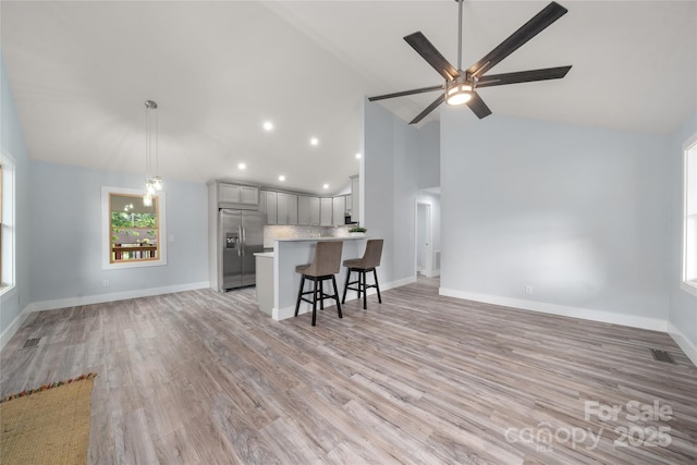 2513 Rolfe St, Hendersonville, NC 28791 - kitchen featuring stainless steel refrigerator with ice dispenser, open floor plan, a kitchen breakfast bar, light countertops, and gray cabinetry