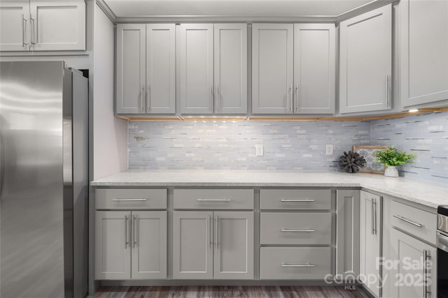 2513 Rolfe St, Hendersonville, NC 28791 - kitchen with freestanding refrigerator, gray cabinetry, backsplash, and light stone countertops