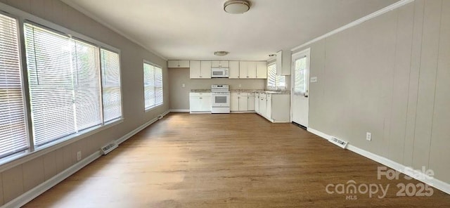 2828 Bellhaven Cir, Charlotte, NC 28214 - kitchen with range, white microwave, wood finished floors, and white cabinets