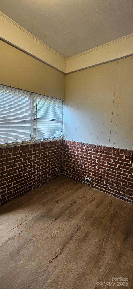 2828 Bellhaven Cir, Charlotte, NC 28214 - spare room featuring wood finished floors and brick wall