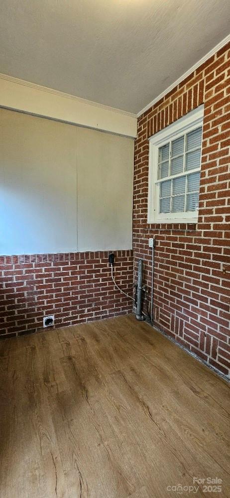 2828 Bellhaven Cir, Charlotte, NC 28214 - empty room with wood finished floors and brick wall