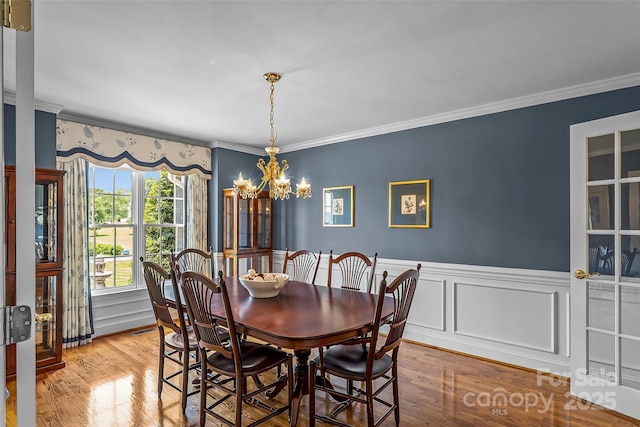 1236 James Farm Rd, Hickory, NC 28602 - dining space with crown molding, a chandelier, wainscoting, and wood finished floors