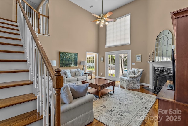 1236 James Farm Rd, Hickory, NC 28602 - living area featuring stairway, a high ceiling, ceiling fan, wood finished floors, and a premium fireplace