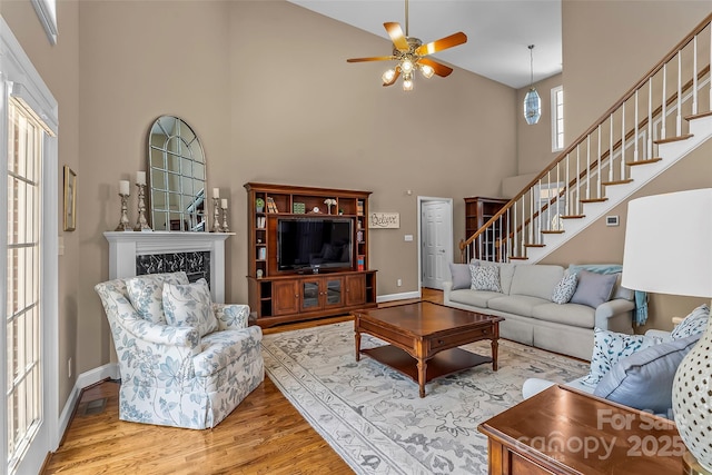 1236 James Farm Rd, Hickory, NC 28602 - living room with high vaulted ceiling, stairway, wood finished floors, a ceiling fan, and a fireplace