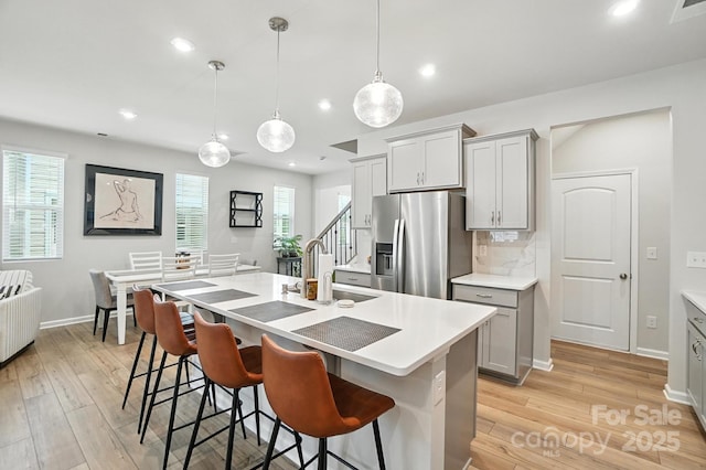 11246 Bartrams Way, Charlotte, NC 28278 - kitchen featuring stainless steel fridge with ice dispenser, light wood-style flooring, gray cabinets, and recessed lighting
