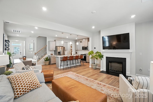11246 Bartrams Way, Charlotte, NC 28278 - living room featuring light wood finished floors, stairs, recessed lighting, and a fireplace with flush hearth