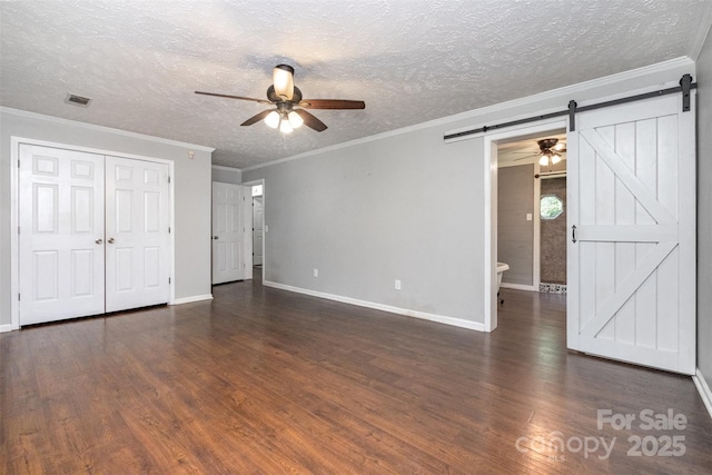 6811 Kluttz Rd, Concord, NC 28025 - unfurnished living room with a barn door, ceiling fan, wood finished floors, a textured ceiling, and crown molding