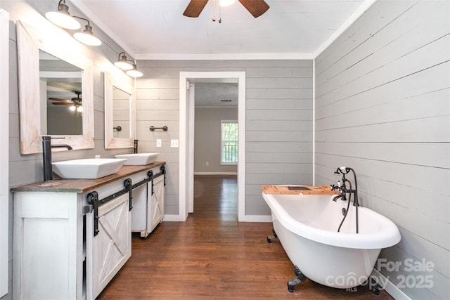 6811 Kluttz Rd, Concord, NC 28025 - bathroom with ceiling fan, wood finished floors, double vanity, a freestanding bath, and wood walls
