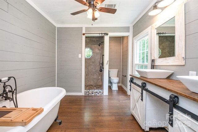 6811 Kluttz Rd, Concord, NC 28025 - full bathroom featuring wood finished floors, a shower stall, a freestanding bath, double vanity, and a ceiling fan