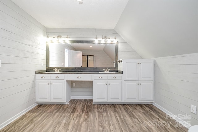 6811 Kluttz Rd, Concord, NC 28025 - bathroom featuring double vanity, wood finished floors, wood walls, and vaulted ceiling