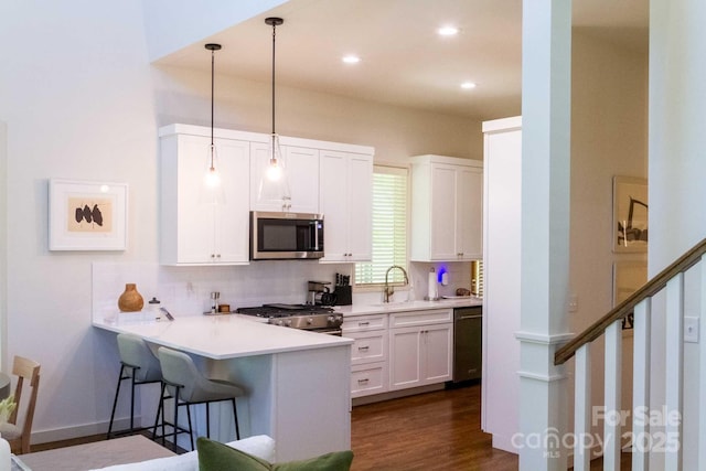 12 Fay Jones Ln, Black Mountain, NC 28711 - kitchen with stainless steel appliances, decorative backsplash, a breakfast bar, a peninsula, and white cabinetry