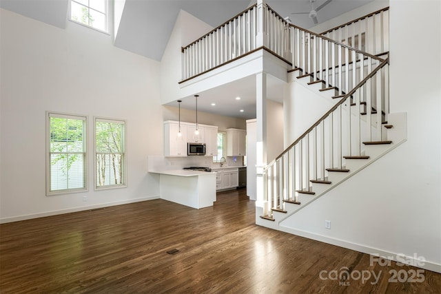 12 Fay Jones Ln, Black Mountain, NC 28711 - unfurnished living room with a high ceiling, dark wood-style flooring, stairway, and ceiling fan