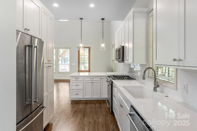 12 Fay Jones Ln, Black Mountain, NC 28711 - kitchen with high quality appliances, a peninsula, light countertops, dark wood-style flooring, and tasteful backsplash